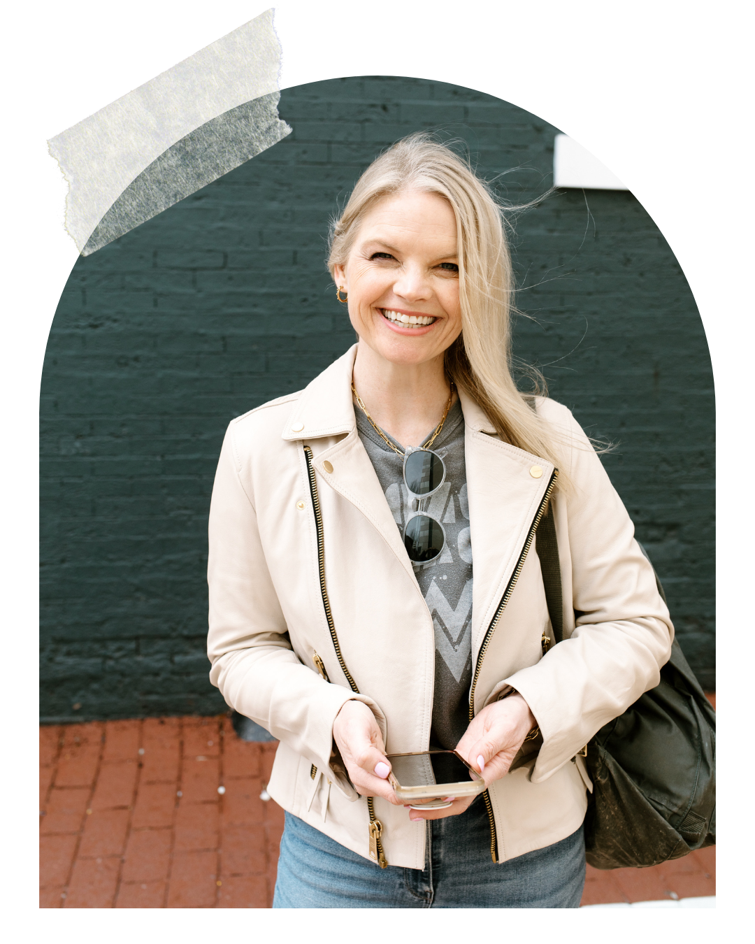 Em Connors holding her phone, standing outside smiling