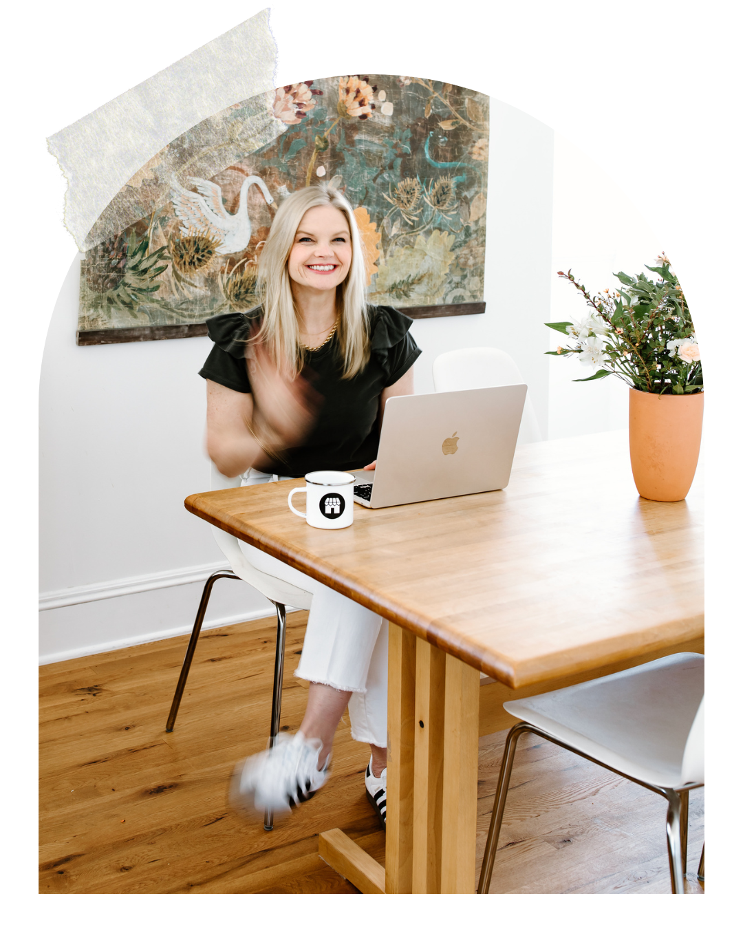 Emily smiling sitting at a table with her laptop
