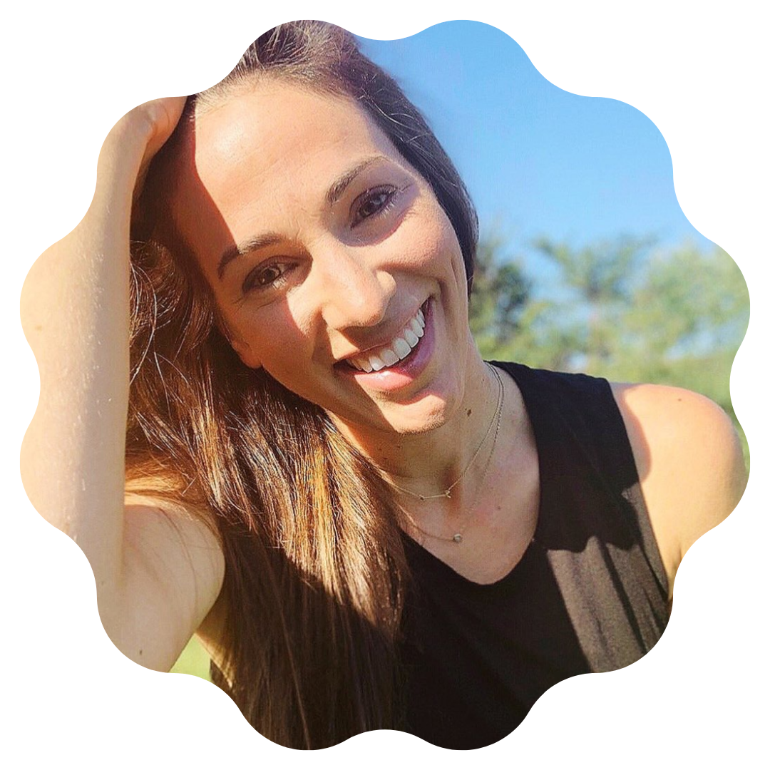 woman with brown hair wearing a black tank top smiling at the camera