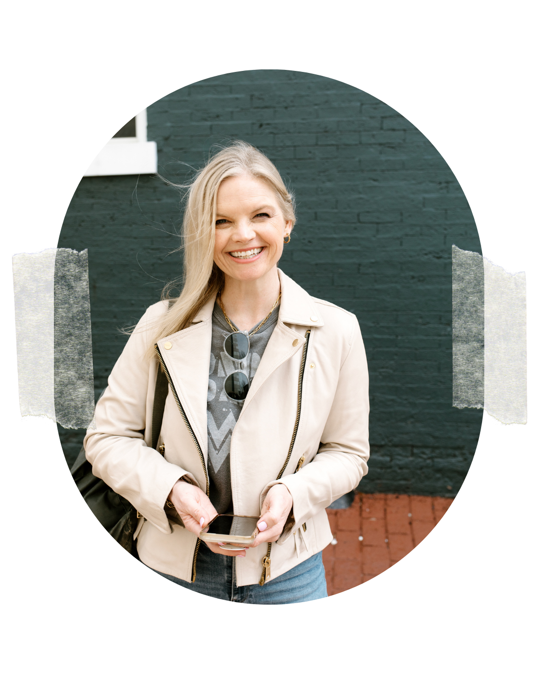 Em holding her phone, standing outside smiling